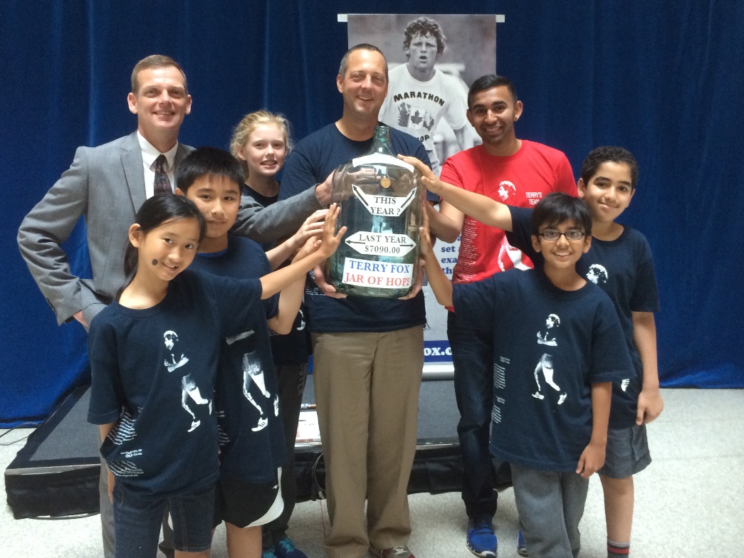 Darrell Fox, left, with children from Orde Street school and their teacher holding their Jar of Hope and with Yusuf Hirji, in red, representing the Terry Fox Foundation